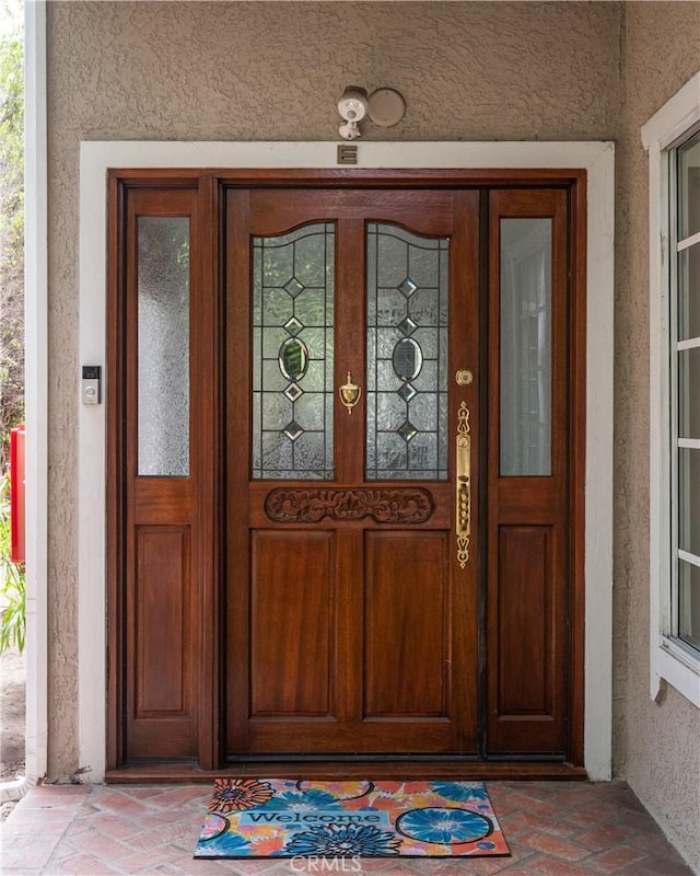 entrance to property featuring stucco siding