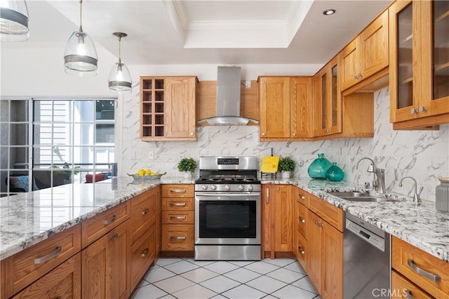 kitchen featuring stainless steel appliances, a sink, wall chimney range hood, glass insert cabinets, and crown molding