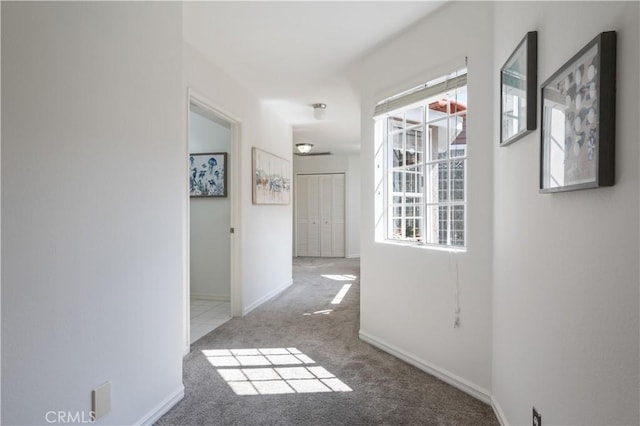 hallway with carpet and baseboards