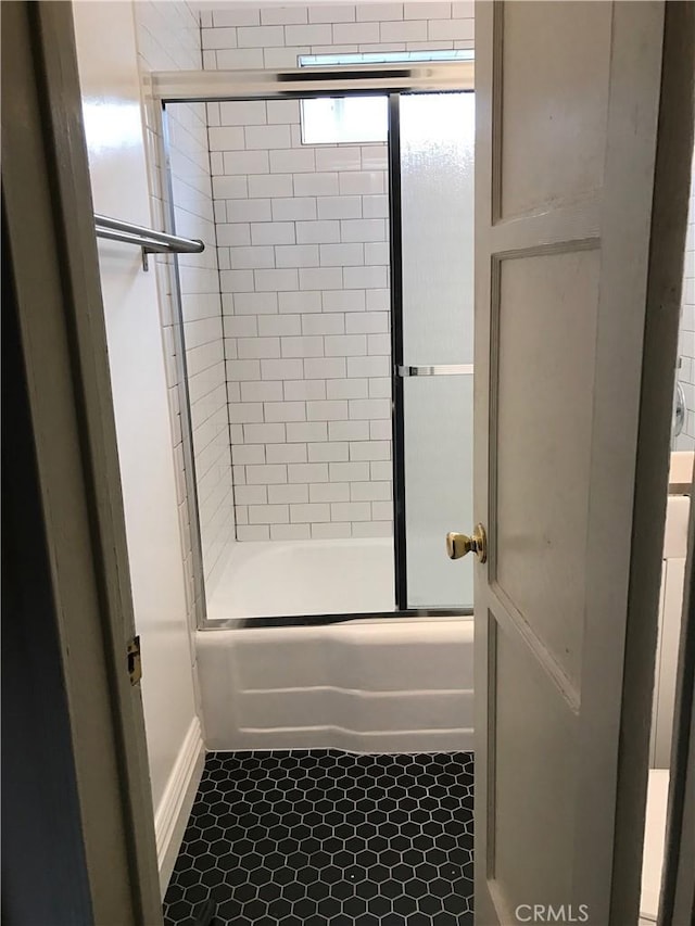 full bath with shower / bath combination with glass door and tile patterned floors