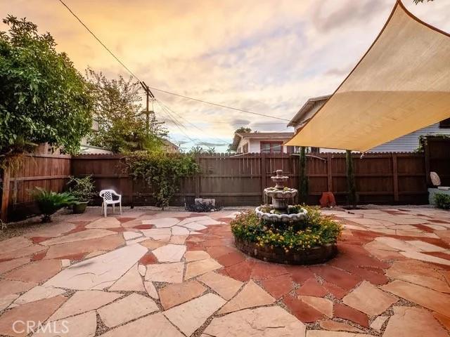 patio terrace at dusk featuring a fenced backyard