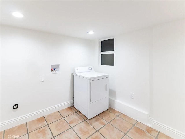 laundry area with laundry area, washer / clothes dryer, light tile patterned flooring, and baseboards