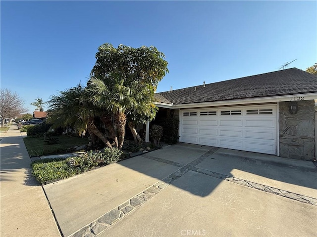 7122 Bluesails Dr, Huntington Beach, CA 92647 - view of front of home featuring stone siding, concrete driveway, roof with shingles, and an attached garage