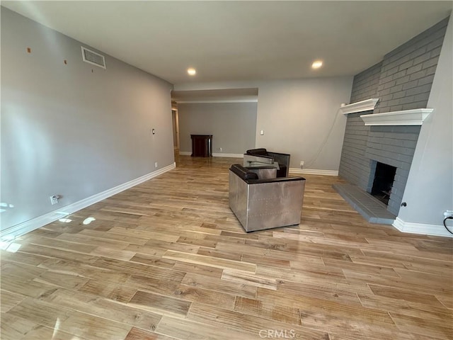 7122 Bluesails Dr, Huntington Beach, CA 92647 - living area featuring baseboards, visible vents, light wood-type flooring, a brick fireplace, and recessed lighting