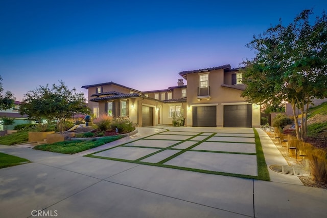 mediterranean / spanish-style home with a garage, concrete driveway, a tile roof, cooling unit, and stucco siding