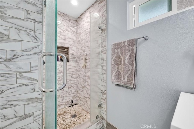 full bathroom with a textured wall and a shower stall