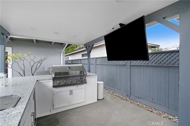 view of patio / terrace featuring grilling area, an outdoor kitchen, and a fenced backyard