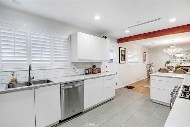 kitchen with appliances with stainless steel finishes, white cabinets, decorative light fixtures, and a sink