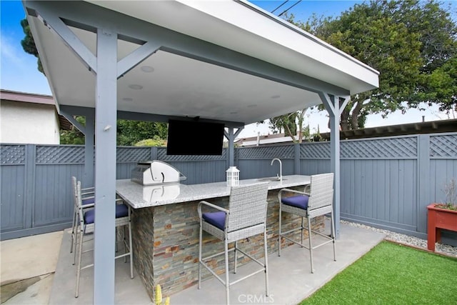 view of patio featuring outdoor dry bar, grilling area, fence, and area for grilling