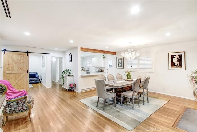 dining room featuring light wood finished floors, recessed lighting, visible vents, a barn door, and baseboards