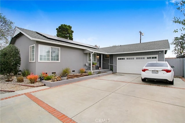 single story home with a garage, driveway, crawl space, roof mounted solar panels, and stucco siding