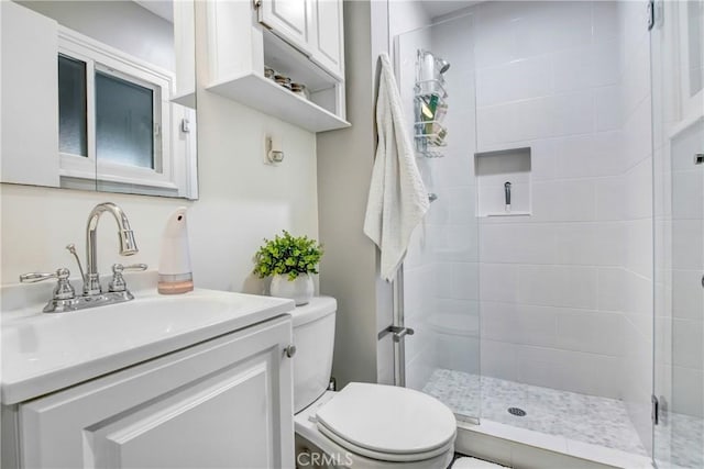 full bathroom with vanity, toilet, and a shower stall