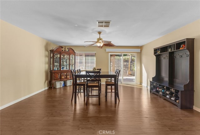 dining area featuring ceiling fan, dark wood finished floors, visible vents, and baseboards