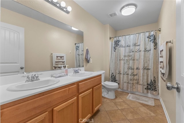 bathroom with visible vents, a sink, toilet, and double vanity