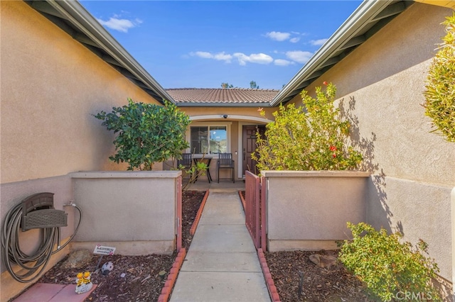 doorway to property featuring fence and stucco siding