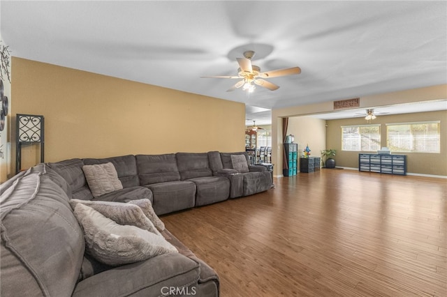 living area with baseboards, ceiling fan, visible vents, and wood finished floors