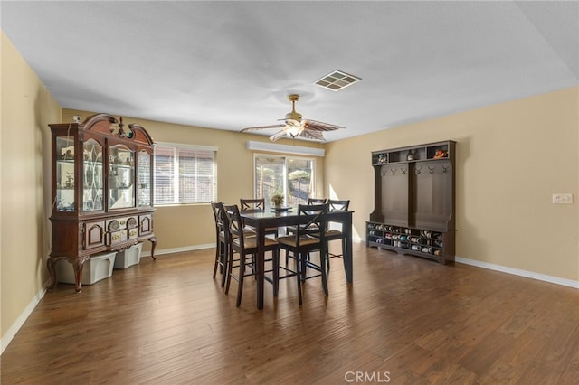 dining space featuring a ceiling fan, baseboards, visible vents, and dark wood-type flooring