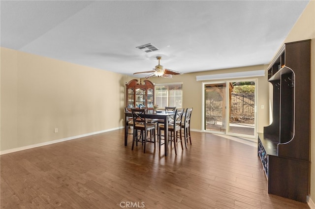 dining room featuring a ceiling fan, baseboards, visible vents, and dark wood-style flooring