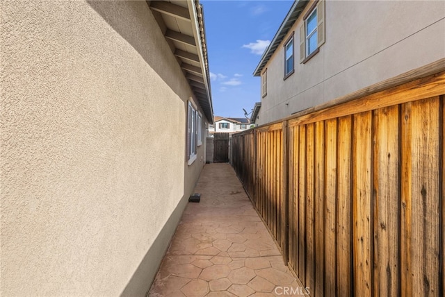 view of side of property with fence and stucco siding