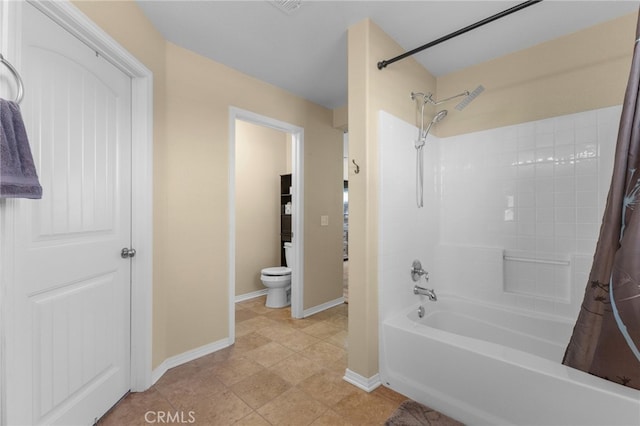 bathroom with shower / bath combo, baseboards, and toilet