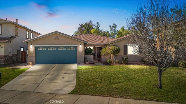 mediterranean / spanish-style house with concrete driveway, stucco siding, a tiled roof, an attached garage, and a front yard