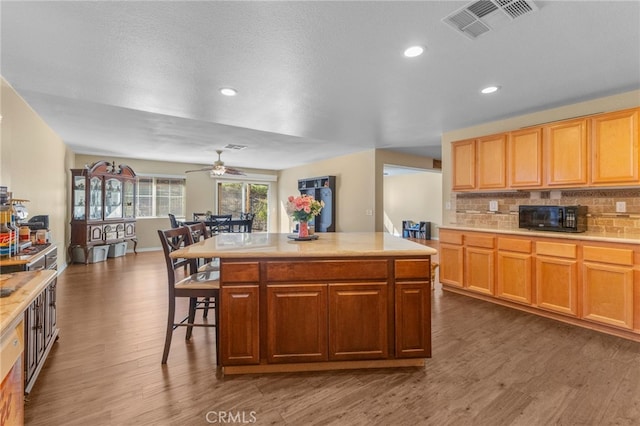 kitchen featuring visible vents, light countertops, and a center island