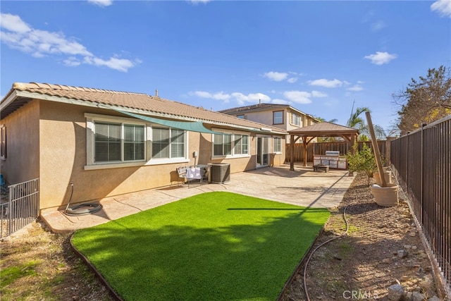 rear view of house featuring a fenced backyard, cooling unit, a gazebo, a patio area, and stucco siding