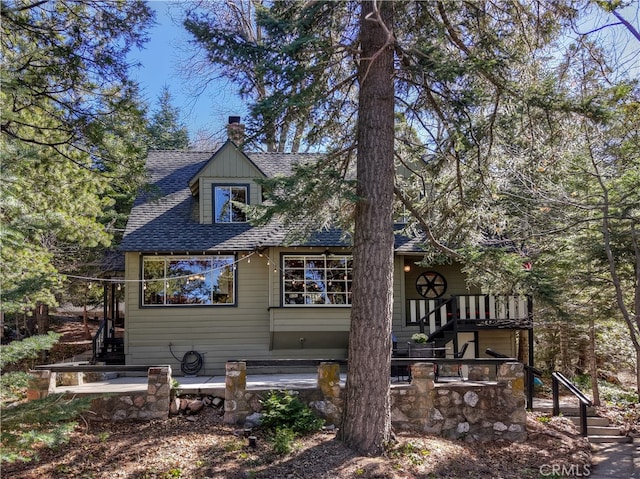 177 Joaquin Miller Rd, Lake Arrowhead, CA 92352 - back of house featuring stairway, roof with shingles, and a chimney