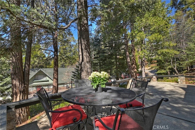 177 Joaquin Miller Rd, Lake Arrowhead, CA 92352 - deck with outdoor dining area, a patio, and view of wooded area