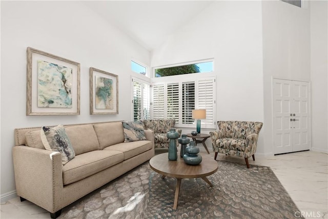 living room with high vaulted ceiling and baseboards