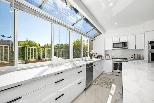 kitchen featuring appliances with stainless steel finishes, light stone counters, and modern cabinets