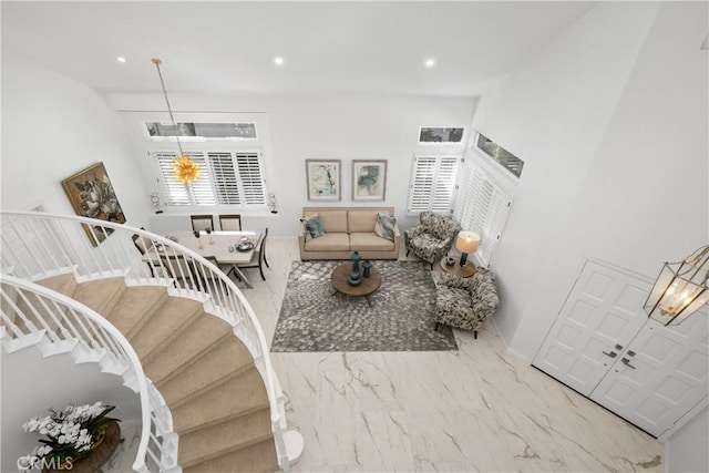 living room with recessed lighting, marble finish floor, and stairs