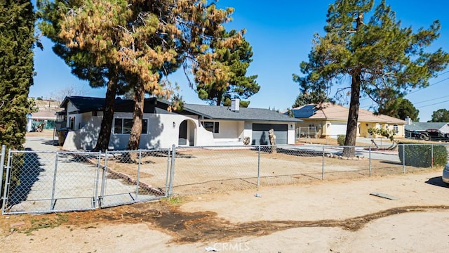 ranch-style house with a garage, driveway, a fenced front yard, and stucco siding