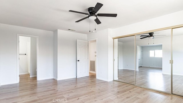 unfurnished bedroom featuring a closet, visible vents, ceiling fan, light wood-type flooring, and baseboards