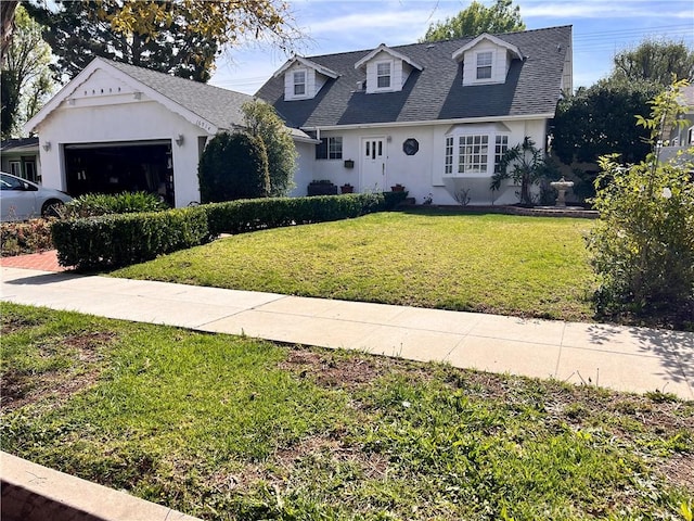 view of front of home featuring roof with shingles, stucco siding, an attached garage, and a front yard