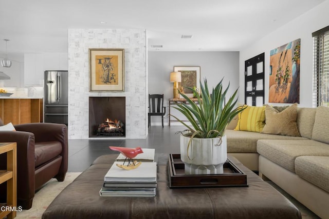 living area with visible vents and a stone fireplace