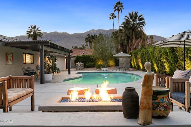 outdoor pool with a patio area, an outdoor fire pit, a mountain view, and a pergola