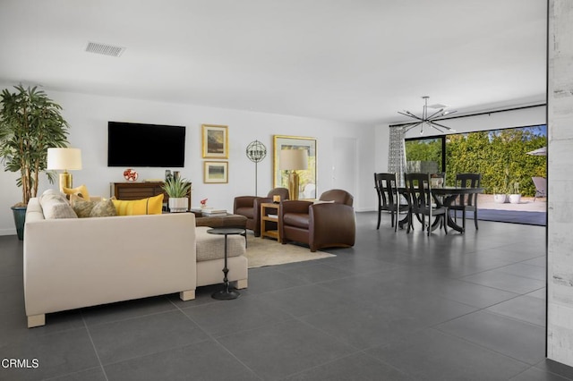 living area with a chandelier, dark tile patterned flooring, and visible vents