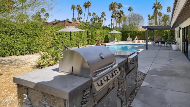 outdoor pool featuring a grill, a patio, and an outdoor kitchen