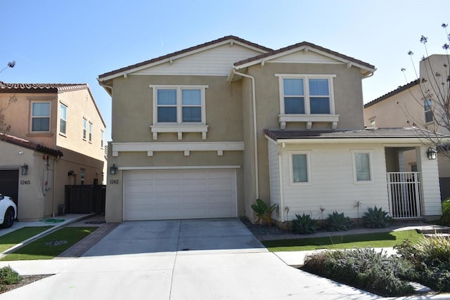 traditional home featuring a tile roof, stucco siding, concrete driveway, and a garage