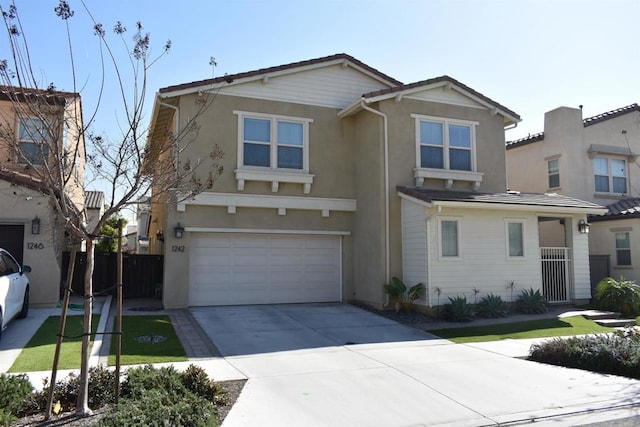 traditional home featuring concrete driveway, an attached garage, fence, and stucco siding