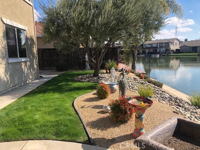 view of yard with a water view and fence