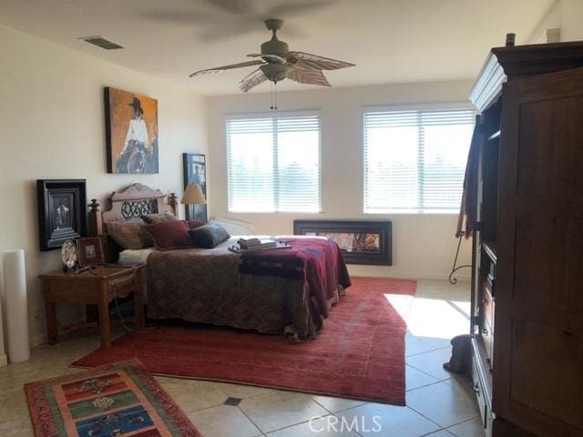 bedroom with ceiling fan, multiple windows, light tile patterned flooring, and visible vents