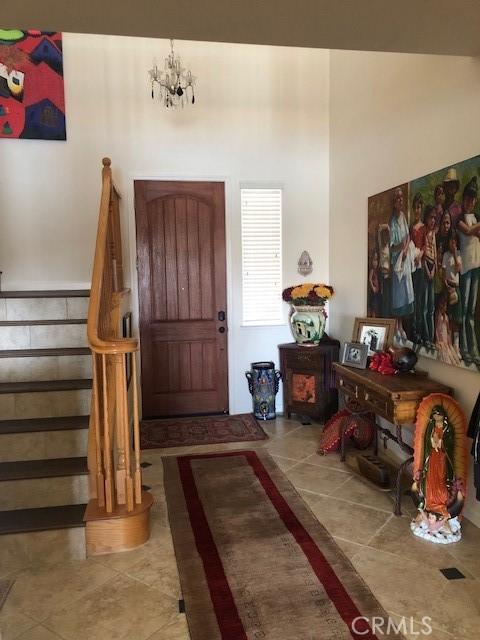 foyer featuring stairway and an inviting chandelier