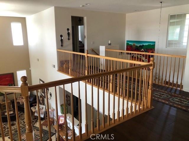 hallway with an upstairs landing and wood finished floors