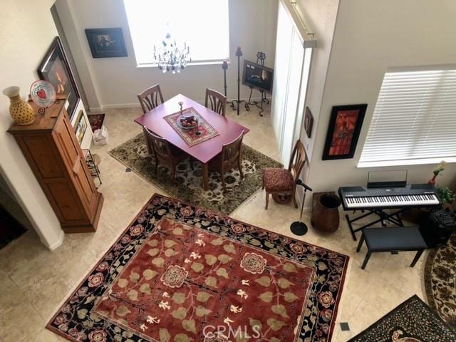 recreation room with light tile patterned flooring and a notable chandelier