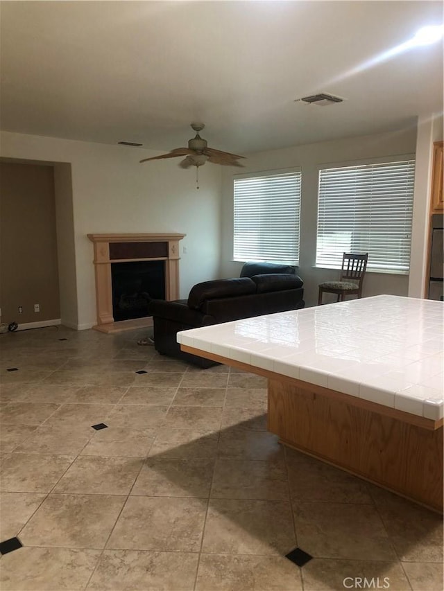 14510 Spyglass Cir, Chowchilla, CA 93610 - living room featuring ceiling fan and a fireplace with raised hearth