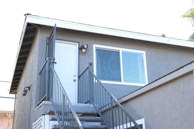 view of exterior entry featuring stucco siding