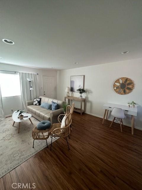 living room with baseboards and dark wood-type flooring