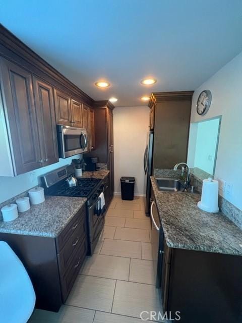 kitchen featuring recessed lighting, baseboards, stainless steel appliances, a sink, and light tile patterned flooring